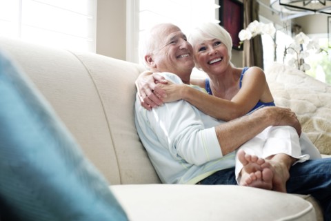 Caucasian couple hugging on sofa