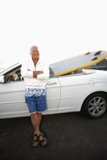 Caucasian man standing with car and paddleboard