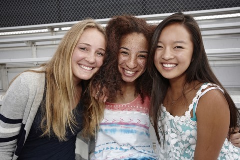 School friends sitting together on bleachers