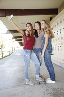 School friends taking self-portrait with cell phone