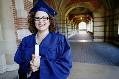 Smiling Caucasian woman holding graduation diploma