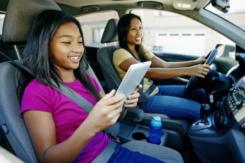 Girl using digital tablet in car