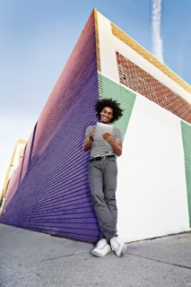 Man using digital tablet and leaning on wall outdoors