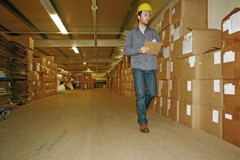 Caucasian worker checking product in warehouse