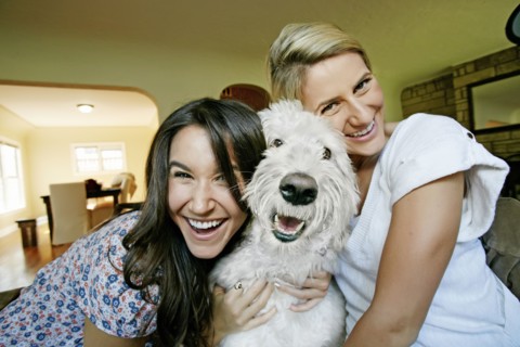 Women petting dog in kitchen