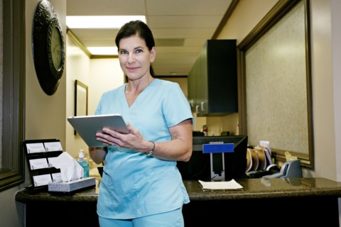 Caucasian nurse using digital tablet in office