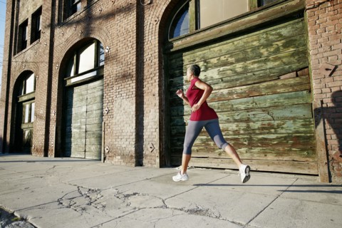 Black woman running on city street