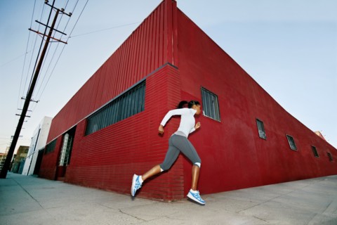 Black woman running on city street