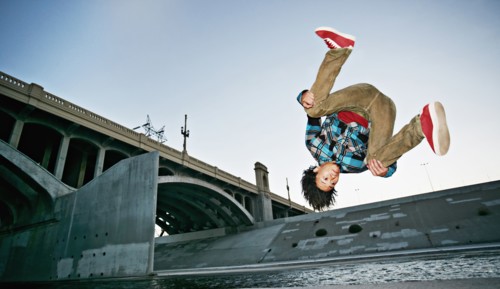 Asian man break dancing under overpass