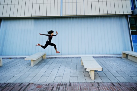 Mixed race woman running on city street