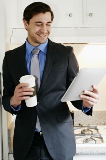 Caucasian businessman using tablet computer in kitchen