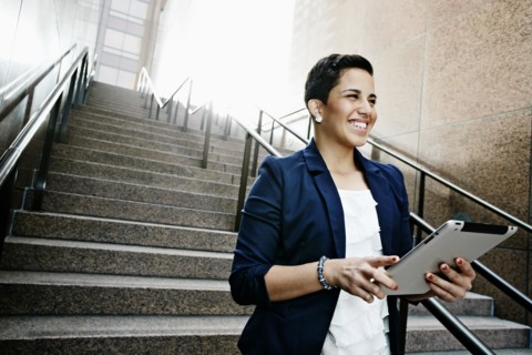 Hispanic businesswoman using tablet computer