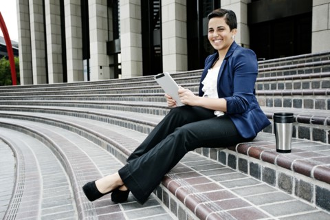 Hispanic businesswoman using tablet computer
