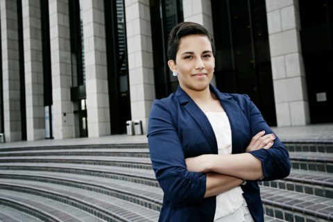 Hispanic businesswoman standing on steps
