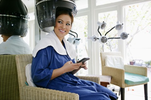 Asian woman having hair done in salon