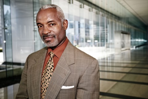 Black businessman smiling in office corridor