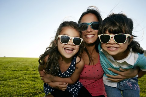 Mother and daughters smiling in field