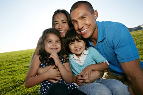 Family smiling together in field
