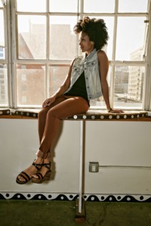 Mixed race woman sitting in window