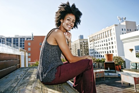 Mixed race woman sitting on urban rooftop