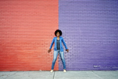 Mixed race woman standing by colorful wall