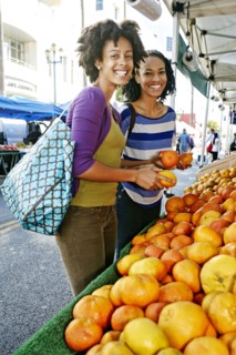 Women shopping together at fruit stand