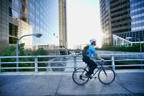 Caucasian businessman riding bicycle on urban street