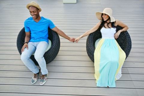 Couple holding hands in wicker chairs