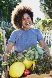 Mixed race woman harvesting vegetables in garden