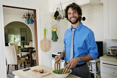 Caucasian businessman cooking in kitchen