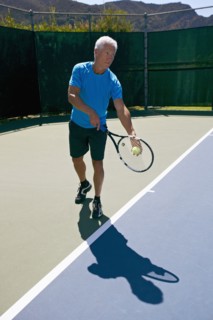 Caucasian man playing tennis on court