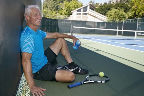 Caucasian man sitting on tennis court