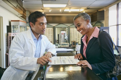 Optometrist talking to patient in office
