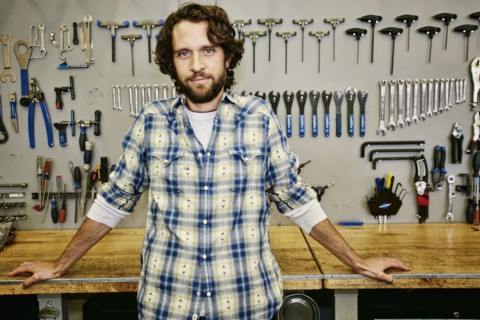 Caucasian man smiling in bicycle repair shop