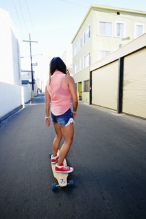 Woman riding longboard on city street