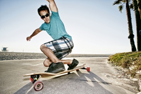 Caucasian man riding longboard on beach