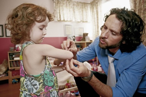 Caucasian father examining daughter's scrape