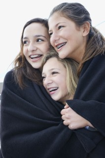 Teenage girls wrapped in blanket together