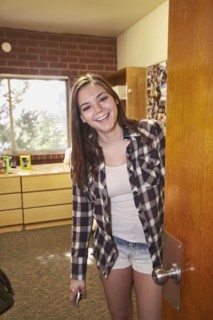 Caucasian student smiling in dorm room