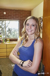 Caucasian student smiling in dorm room