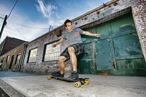Caucasian man riding skateboard on city street