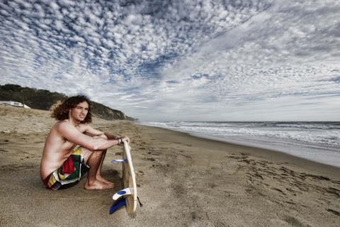 Caucasian man holding surfboard on beach