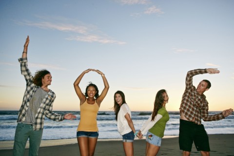 Friends spelling Love on beach
