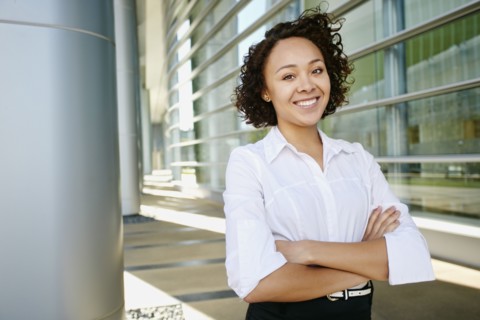 Mixed race businesswoman standing on city street