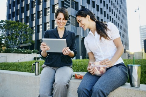 Businesswomen using tablet computer in city