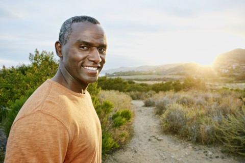 Black man smiling on rural hillside