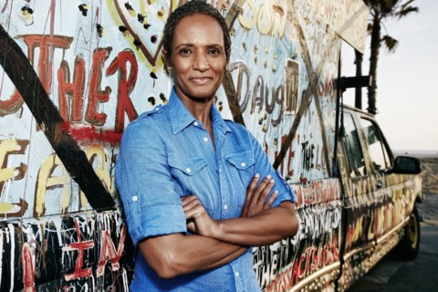 Older Black woman standing by decorated truck
