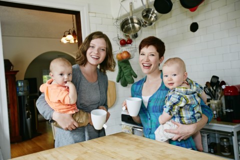 Caucasian mothers holding babies in kitchen