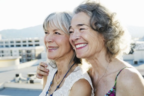 Women smiling together on urban rooftop