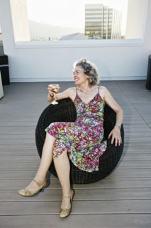 Caucasian woman drinking wine on urban rooftop